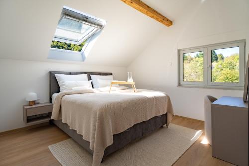 a white bedroom with a bed with a skylight at Villa Peregrine Plitvice Lakes 