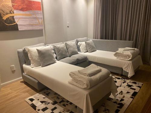 a living room with two beds and a couch at Studio 211 Conforto e Charme in Canela