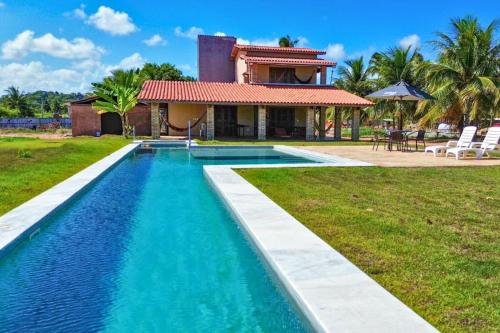 a villa with a swimming pool in front of a house at MHV Milagres - Casa Mar, Refugio a beira mar na Paradisíaca praia da enseada do toque in São Miguel dos Milagres