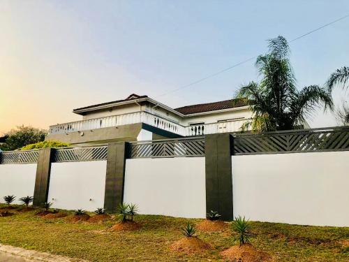 una cerca blanca frente a una casa en Grand Tranquil Views, en Lobamba