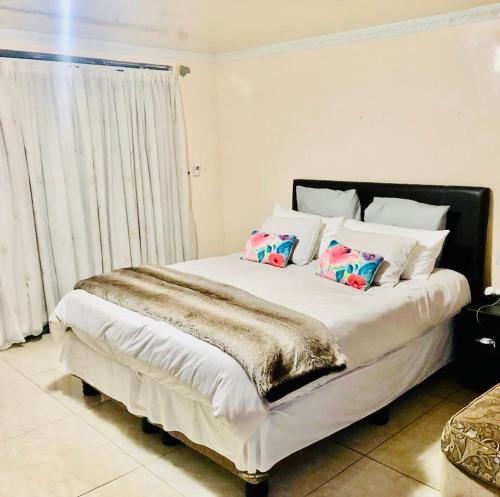 un dormitorio con una cama con dos almohadas. en Grand Tranquil Views, en Lobamba