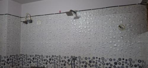 een douche met een muur bedekt met veel water bij Raghuvar Vilas in Varanasi