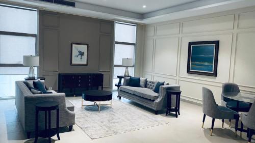 a living room with a couch and chairs and a table at 1 Constitution Avenue By Goldfinch in Islamabad