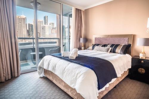 a bedroom with a large bed and a large window at Luxury bay view Darling Harbour Free Parking in Sydney