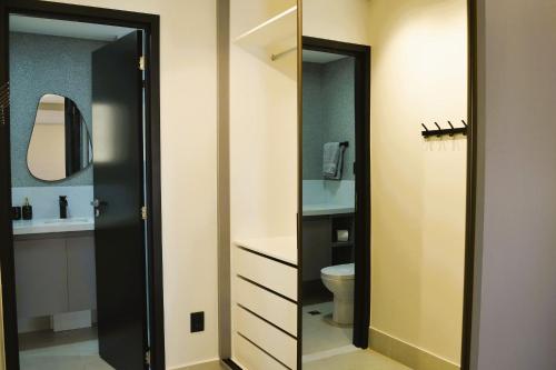 Un baño con espejo, lavabo e inodoro. en Centro Compact Life, en Goiânia