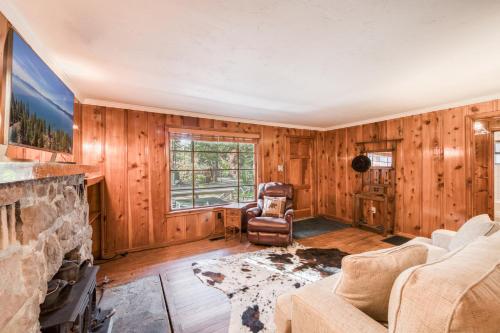 a living room with a fireplace and wooden walls at Diana's Cabin by Tahoe Getaways - Pet-Friendly 2BR in Kings Beach w Backyard & Walk to Lake! in Wood Vista