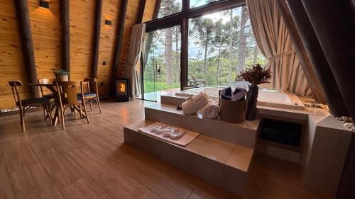 a living room with a large window and a table at Vistas de Mantiqueira in Bom Jardim da Serra