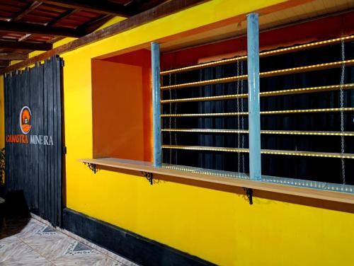 a yellow wall with a window on the side of a building at Pousada e camping Canastra Mineira in São Roque de Minas