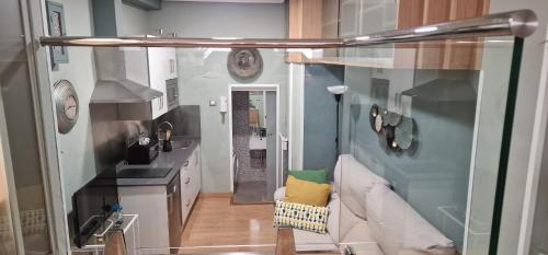 a living room with a couch and a kitchen at La Cámara de El Cristo in Oviedo