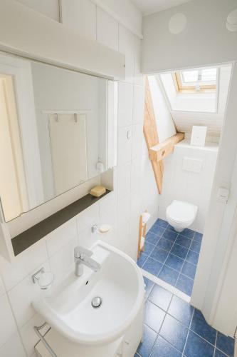 a bathroom with a white sink and a toilet at Aussergewöhnliche Loft Wohnung mit Hängenetzen und Schaukeln in Frauenfeld