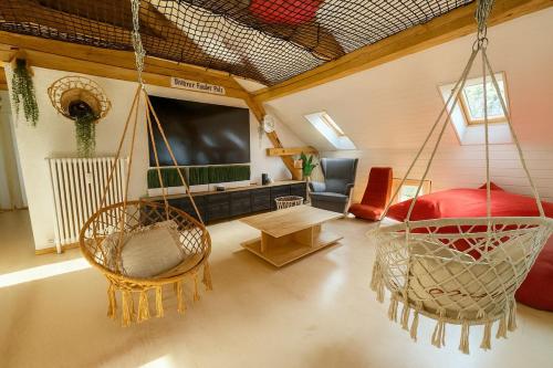 a living room with a hanging chair and a couch at Aussergewöhnliche Loft Wohnung mit Hängenetzen und Schaukeln in Frauenfeld