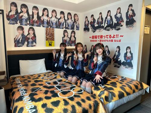 a group of girls sitting on a bed in a room at Henn na Hotel Osaka Namba in Osaka