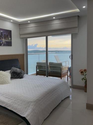a bedroom with a bed and a view of the ocean at Apartamento en Palmetto sunset frente al mar piso 20 in Cartagena de Indias