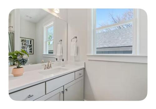 ein weißes Badezimmer mit Waschbecken und Fenster in der Unterkunft Brand New 3 Bed 3 Bath Modern Home in Downtown in Raleigh
