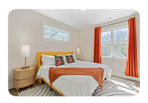 Schlafzimmer mit einem Bett mit orangefarbenen Vorhängen und einem Fenster in der Unterkunft Brand New 3 Bed 3 Bath Modern Home in Downtown in Raleigh