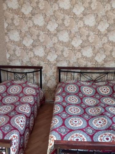 two beds sitting next to each other in a bedroom at Name in Tʼelavi