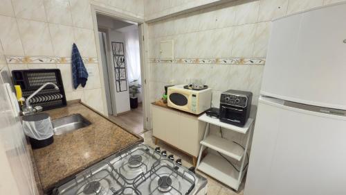 a small kitchen with a sink and a microwave at Apartamento Completo no Centro Serra N in Serra Negra
