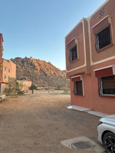 a building in the desert with a mountain in the background at Bright Self-Catering 2 bedroom Apartment in Tafraout in Tafraoute