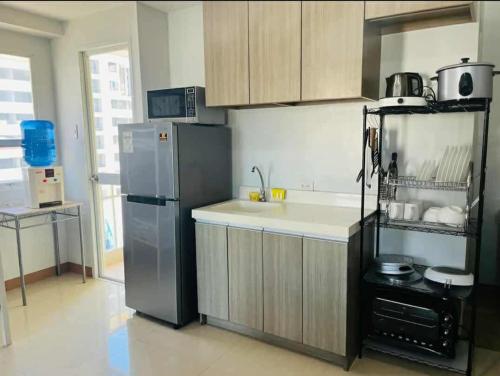 a kitchen with a refrigerator and a sink at Penthouse A Near IT Park in Cebu City