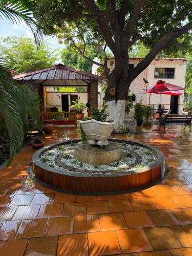 een fontein midden op een binnenplaats met een boom bij Hotel La Casona Valledupar in Valledupar