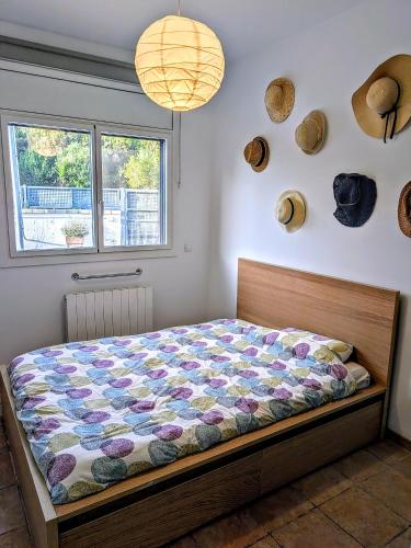 a bed in a bedroom with hats on the wall at Can Altaba in Maçanet de la Selva