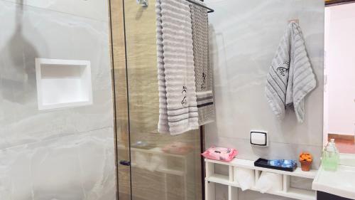 a bathroom with a shower and a sink at Apartamento Pé na Praça Centro Serra Neg in Serra Negra