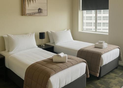 a hotel room with two beds and a window at The Post Hotel in Porirua