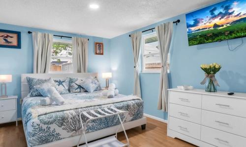 a bedroom with blue walls and a bed and a dresser at Peaceful Family Getaway in Venice in Venice