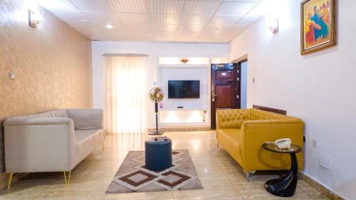 a living room with two couches and a tv at Kings Apartment Ikeja in Ikeja