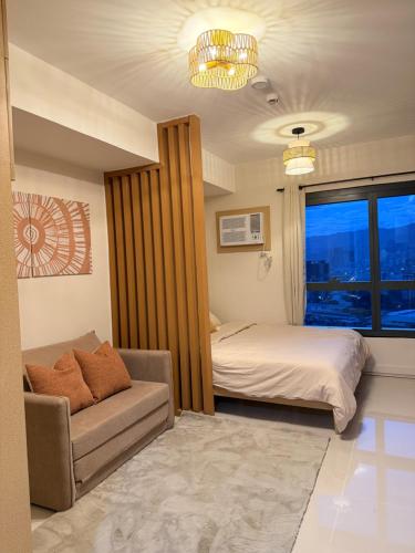 a bedroom with a bed and a couch and a window at Cliffiens Cozy Space in Sampong