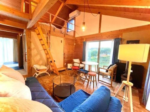 a living room with a blue couch and a table at Gubo Satoyama Suite Lodge & Camp - Vacation STAY 39508v in Katsuura