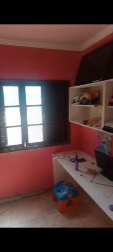 a room with red walls and a desk and a window at Mansão da sull in São Paulo