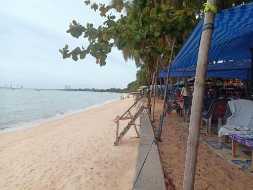 een strand met een blauwe tent en stoelen en de oceaan bij คอปเตอร์ Resort in Ban Khlot