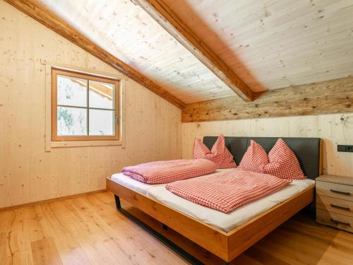 a bedroom with a bed with red pillows on it at Heualm in Hopfgarten im Brixental