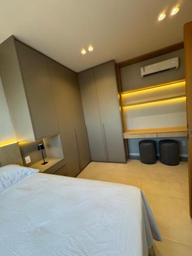 ein Schlafzimmer mit einem weißen Bett und einigen Schränken in der Unterkunft Espetacular Athenas Future in Belém