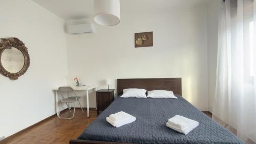 a bedroom with a bed with two towels on it at Casa Vale de Água em Santarém in Santarém