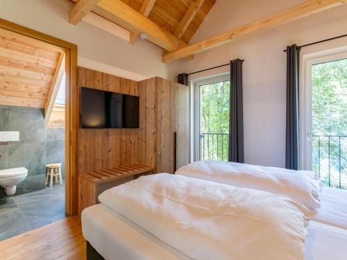 two beds in a room with a tv and a bathroom at Mountain Chalet Alpinchique in Sankt Lorenzen ob Murau
