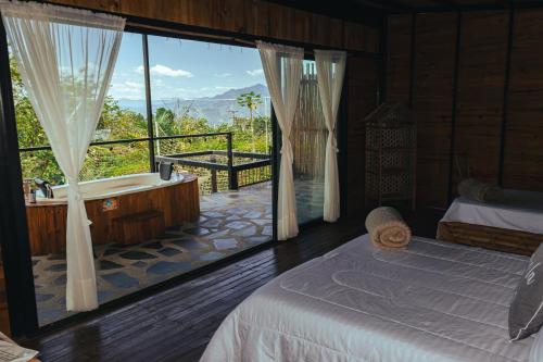 拉维加Finca El Fin del Afán - La Vega的一间带浴缸、床和窗户的卧室