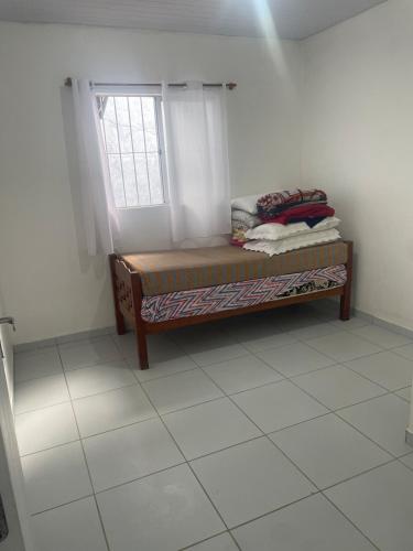 a room with a bench with a window in it at Casa aconchegante in Garanhuns