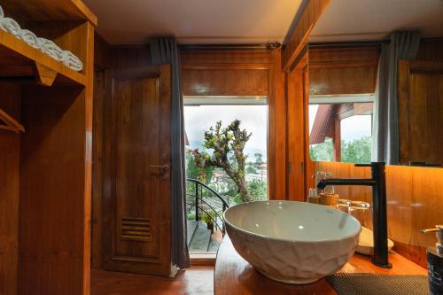 a bathroom with a large bowl sink in front of a window at Pondanu Living in Bedugul