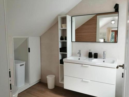 a white bathroom with a sink and a mirror at House Serenity with Pool in Vrgorac
