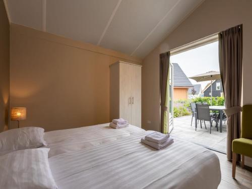 アルメンにあるCozy villa in the middle of the Achterhoekのベッドルーム1室(ベッド1台付)、パティオ(テーブル付)