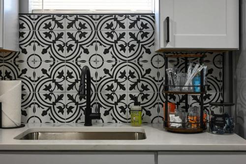 a kitchen sink with a black and white patterned wall at 2BR Home KC Stadiums Great Location I-70 in Blue Springs
