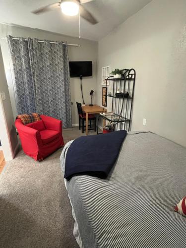 a bedroom with a bed and a red chair at GFU neighborhood and Oregon Wine Country studio in Newberg