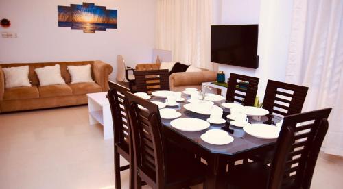 a living room with a table with chairs and a television at 4BR Apt I 2 King SIZE BED I 2 Queen Size bed I Dhanmondi & Crescent Lake, Dhaka in Dhaka