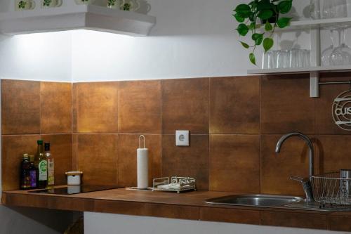 a kitchen with a sink and a counter with brown tiles at Varandas do Vale Furnazinhas in Castro Marim