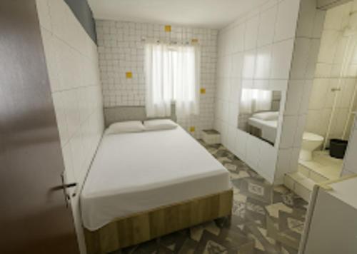 Ein weißes Zimmer mit einem Bett und einem Bad. in der Unterkunft Hotel Gold - Brasília in Brasilia