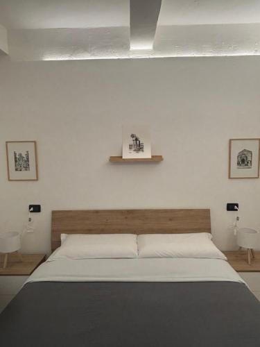 a bedroom with a large bed and two tables at SottoSopra Apartments - In centro a piedi in Ferrara