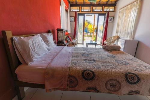 ein Schlafzimmer mit einem großen Bett mit einer roten Wand in der Unterkunft La casa de Jessi in Máncora