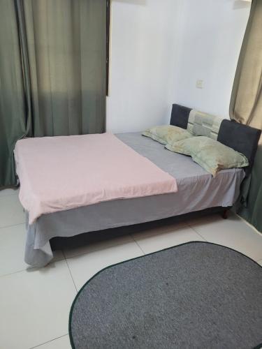 a bedroom with a bed with pink sheets and a rug at Shalom Home Stay in Nadi International Airport